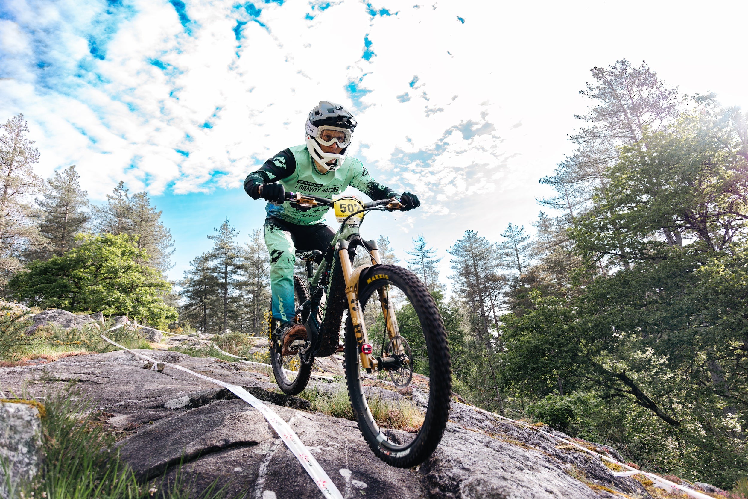 Professional mountain bike racing action featuring TRP brake systems in competitive cycling environment