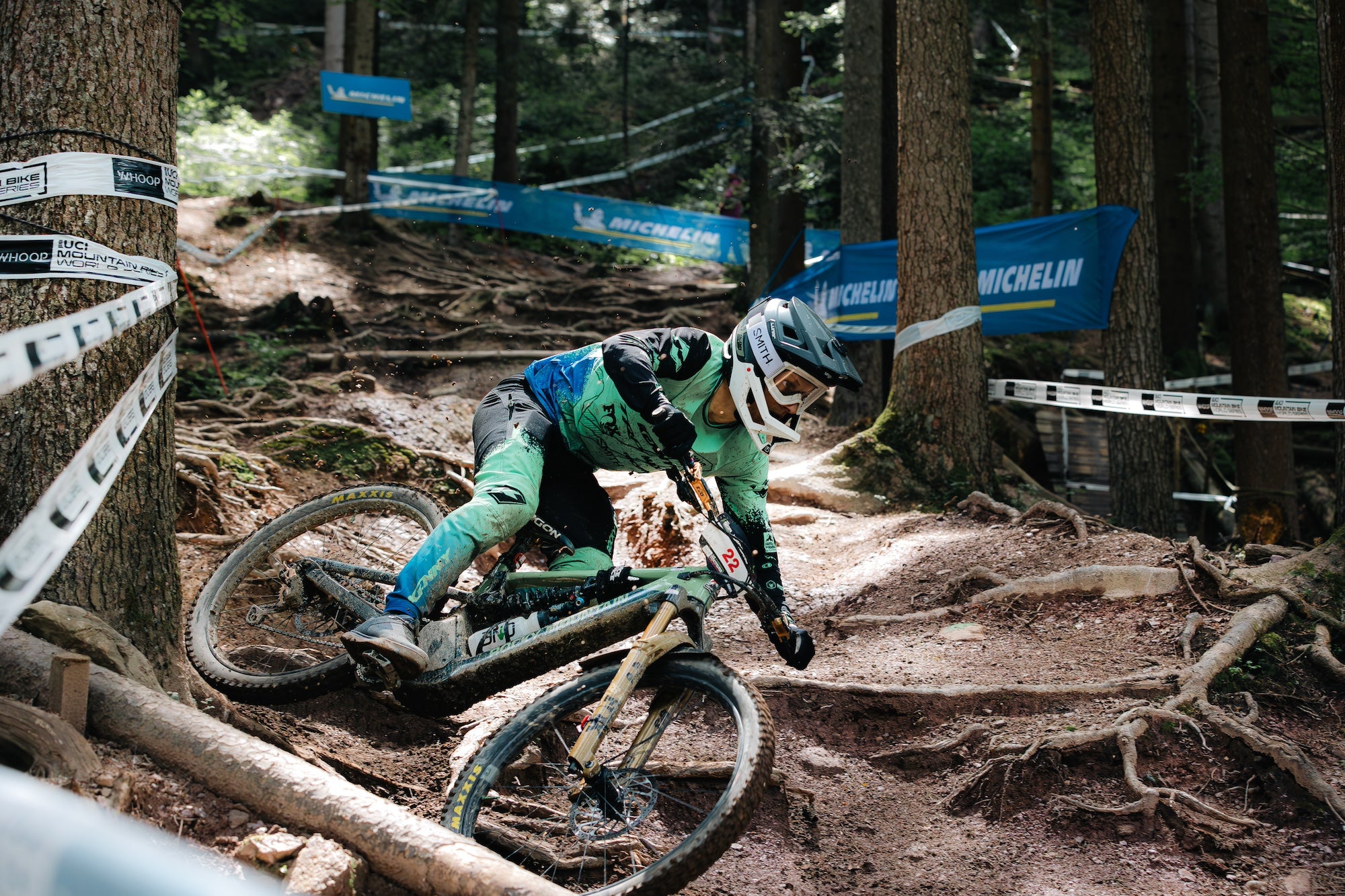 Professional mountain bike racing action featuring TRP brake systems in competitive cycling environment