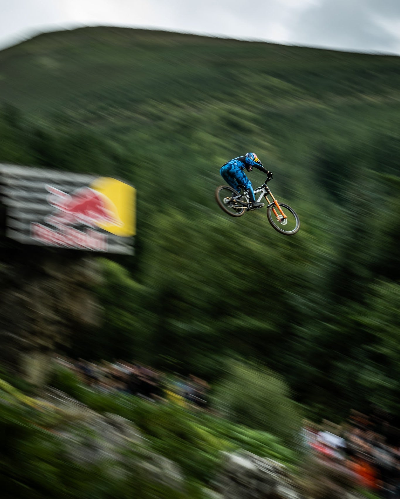 Biker in mid-air performing a stunt with a Red Bull banner in the background