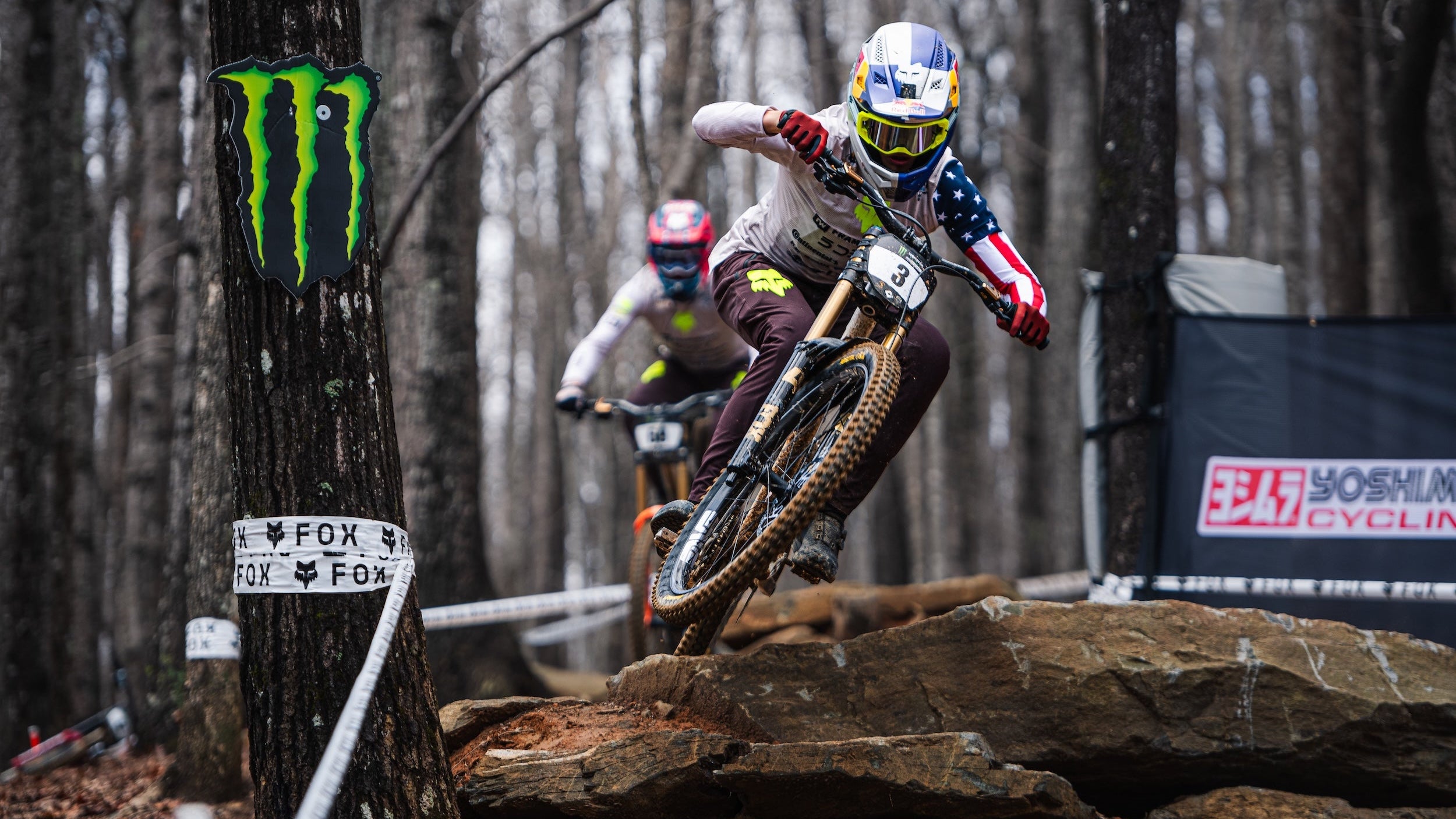 Biker in action on a rocky trail with Monster Energy branding and TRP brakes on the bike in a competition