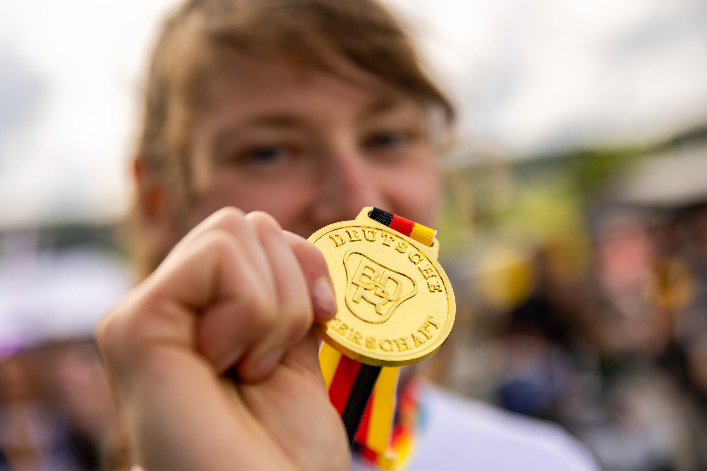 female MTB rider celebrating with a medal at the German Enduro Championship — supported by TRP components