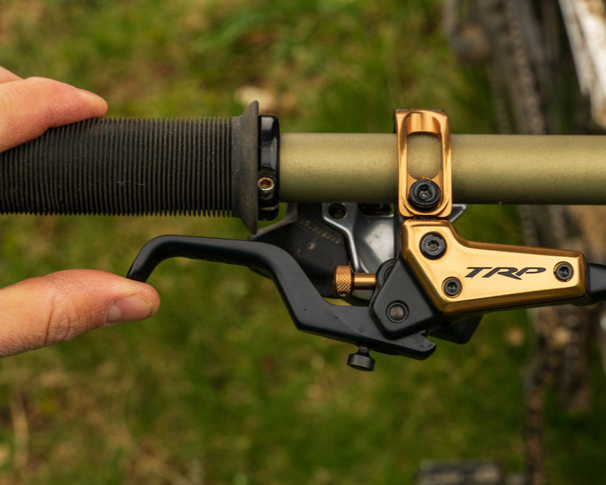 Close up of TRP EVO brake lever on a mountain bike handlebar with a hand pulling the lever