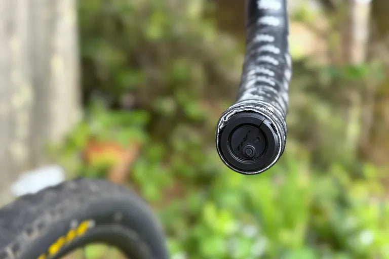 Close-up of a bicycle handlebar with VISTAR bar en Unit for CMD ecosystem on a blurred natural background
