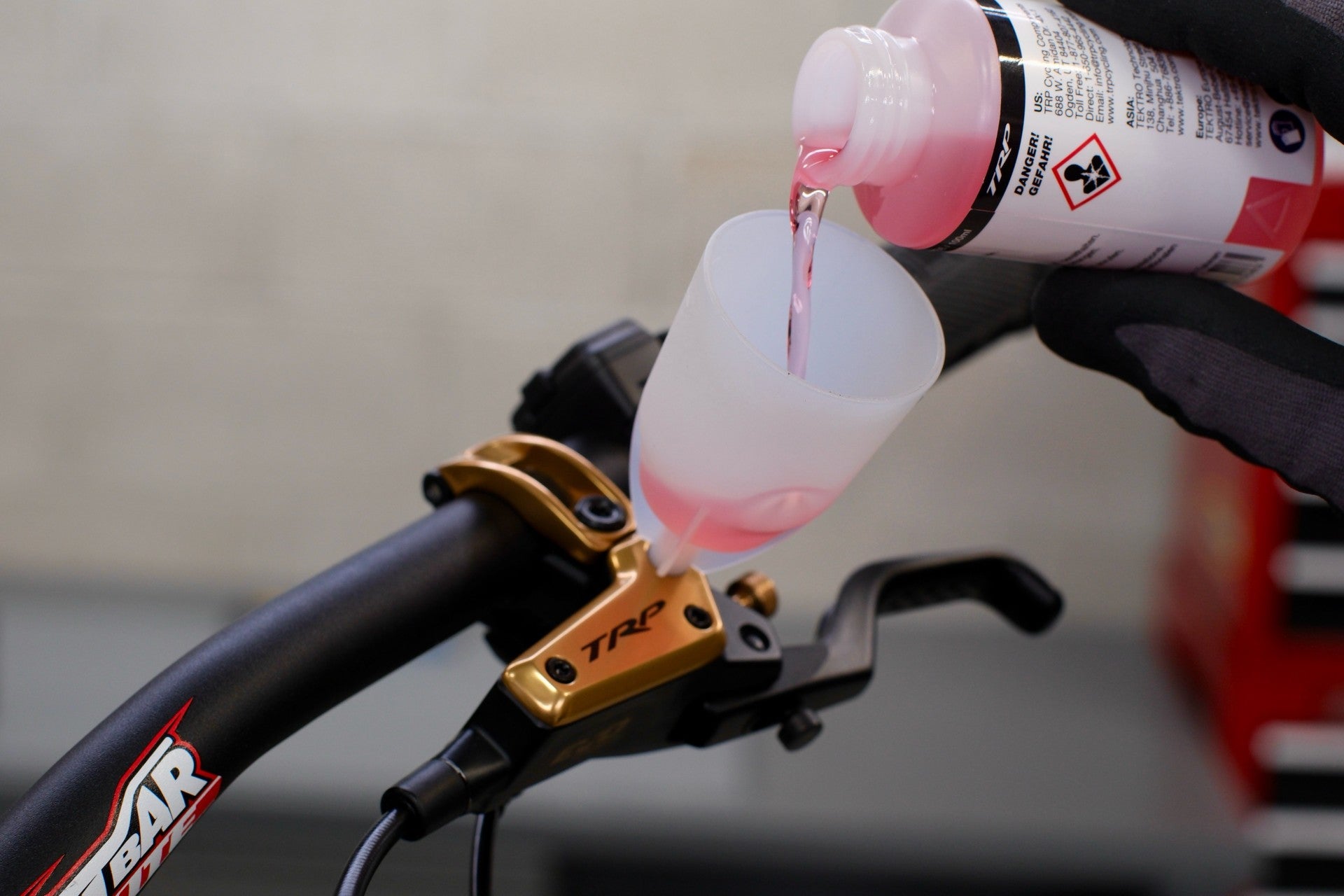 Bicycle brake lever with mineral oil being poured into it, for bleeding.