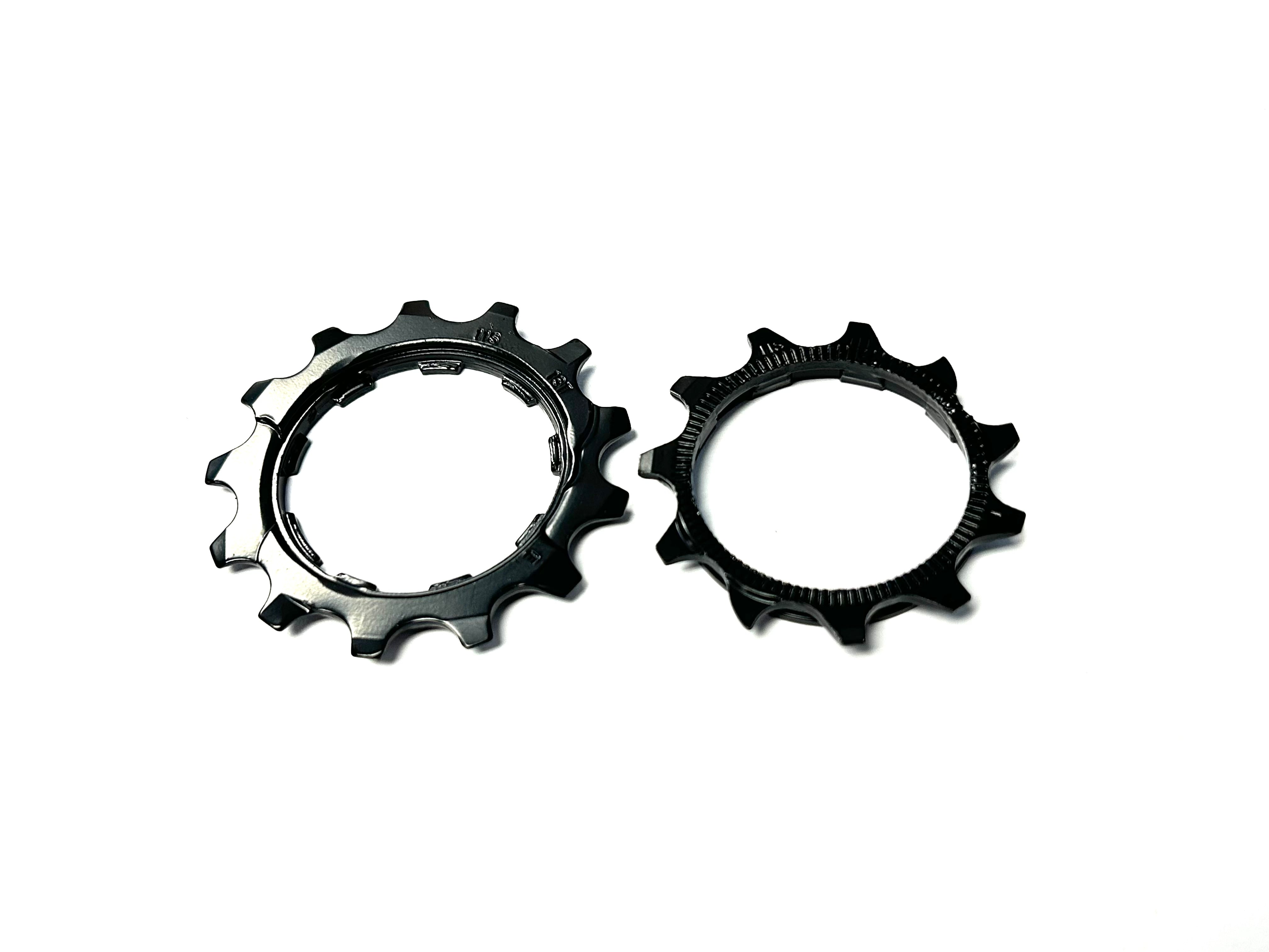 Two black metal bike sprocket wheels on a white background